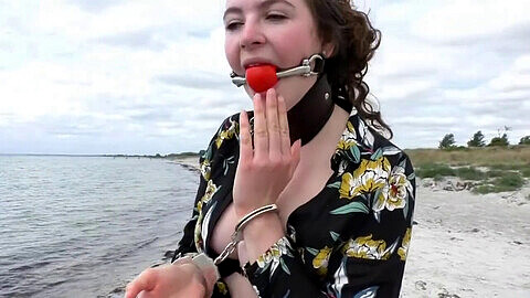 Submissive Mia gets ball-gagged, handcuffed and humiliated at the beach