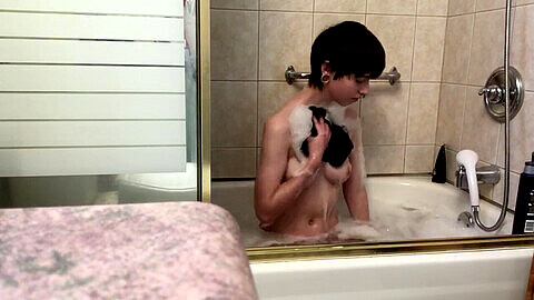Jeune androgyne de 19 ans prend un bain moussant sensuel tout en se faisant percer