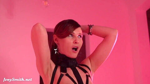 Hermosa Jeny Smith posa en rosa con medias negras y tacones altos.