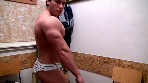 Joven culturista musculoso Hercule muestra sus músculos en la webcam para sus admiradores