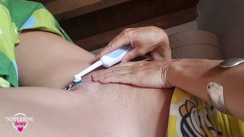 Mamma porca con piercing ai capezzoli si masturba con una figa piercing e uno spazzolino da denti