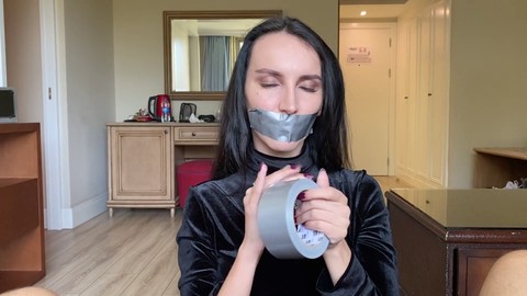 Black-haired beauty gives duct-tape handjob with mouth taped shut and receives cumshot on her pretty face