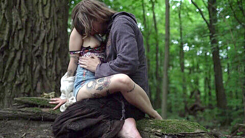 Hippie couple with dreadlocks enjoy outdoor petting in the forest