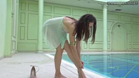 La sensual adolescente pequeña Lizi Vogue nada desnuda en la piscina