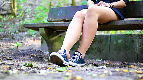 Schuhspiel im Freien mit meinen nylonbestrumpften Füßen in flachen Schuhen und Converse-Sneakern.