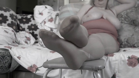 Mature lady with chubby droopy tits shows off her nylon-clad feet