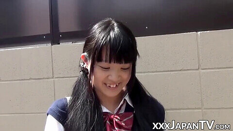 Kleine asiatische Studentin spielt mit ihrer Muschi über dem Höschen